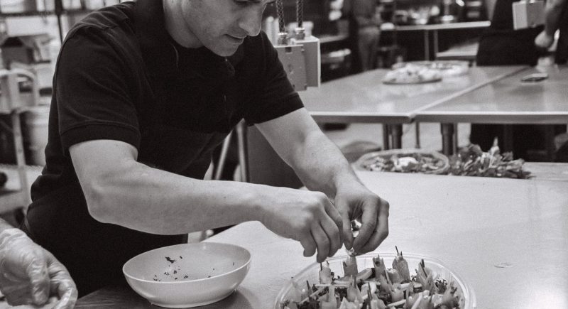 An employee of Pressed Cafe assembling a dish for a customer