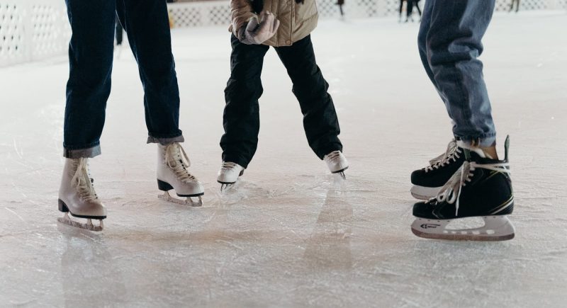 The legs of three people ice skating