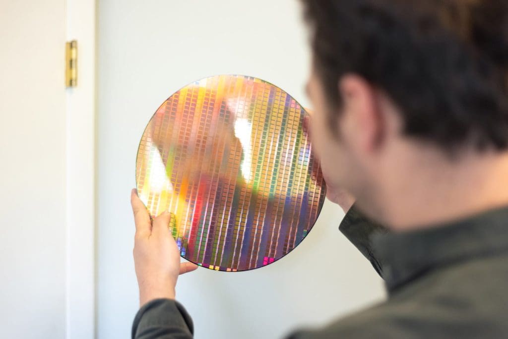 An employee from SiPhox holding up a product
